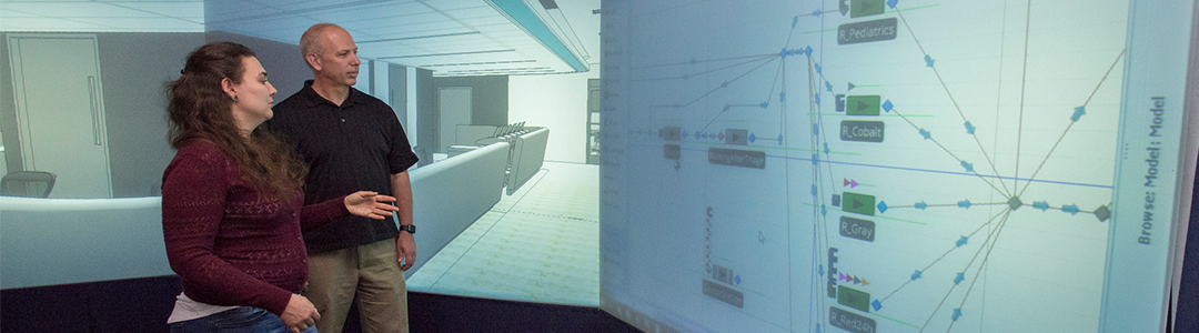 Two people standing in front of a presentation screen